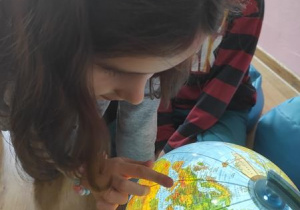 Lena pokazuje Włochy na globusie.
